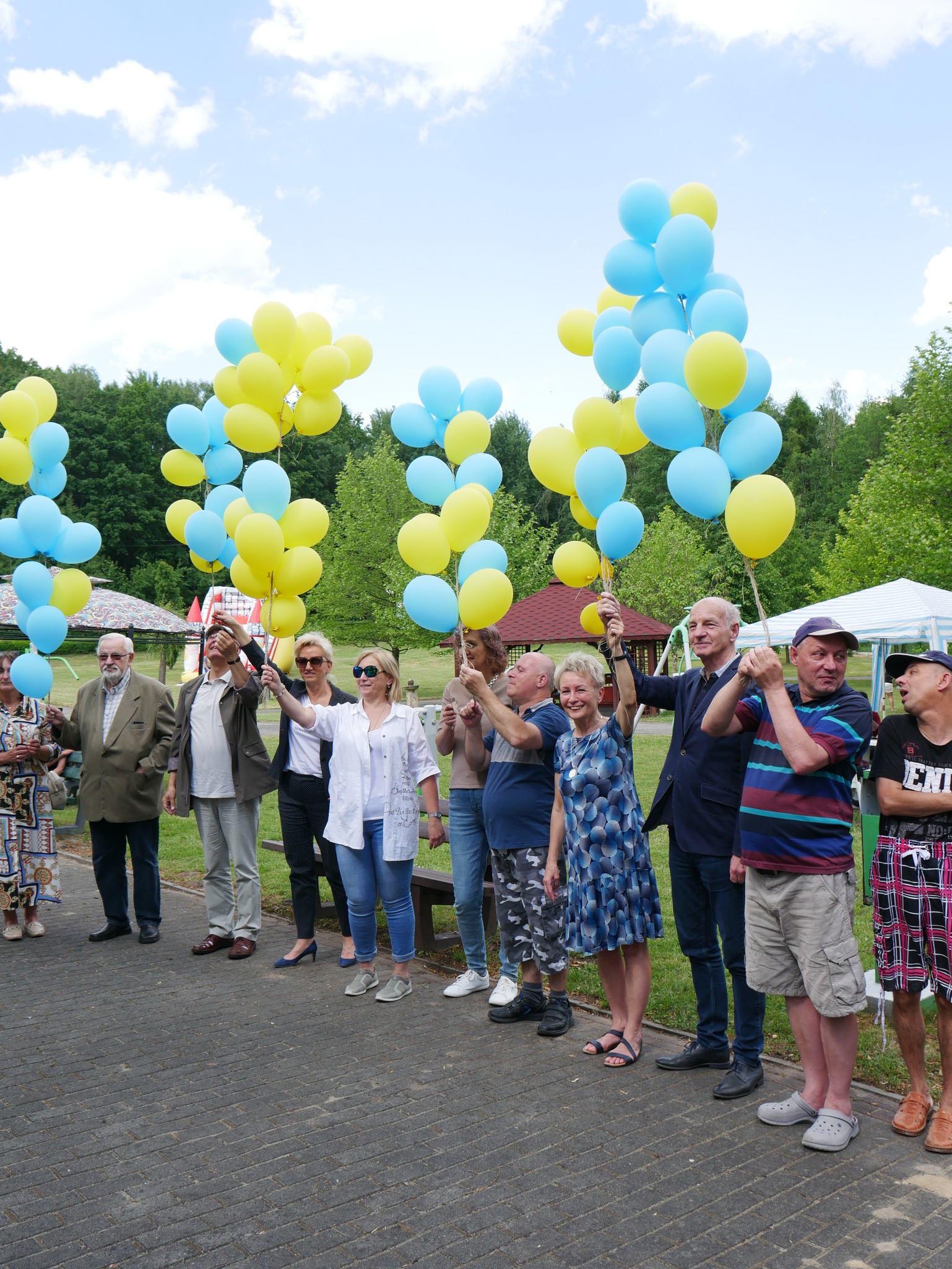 Goście trzymają żółto-niebieskie balony