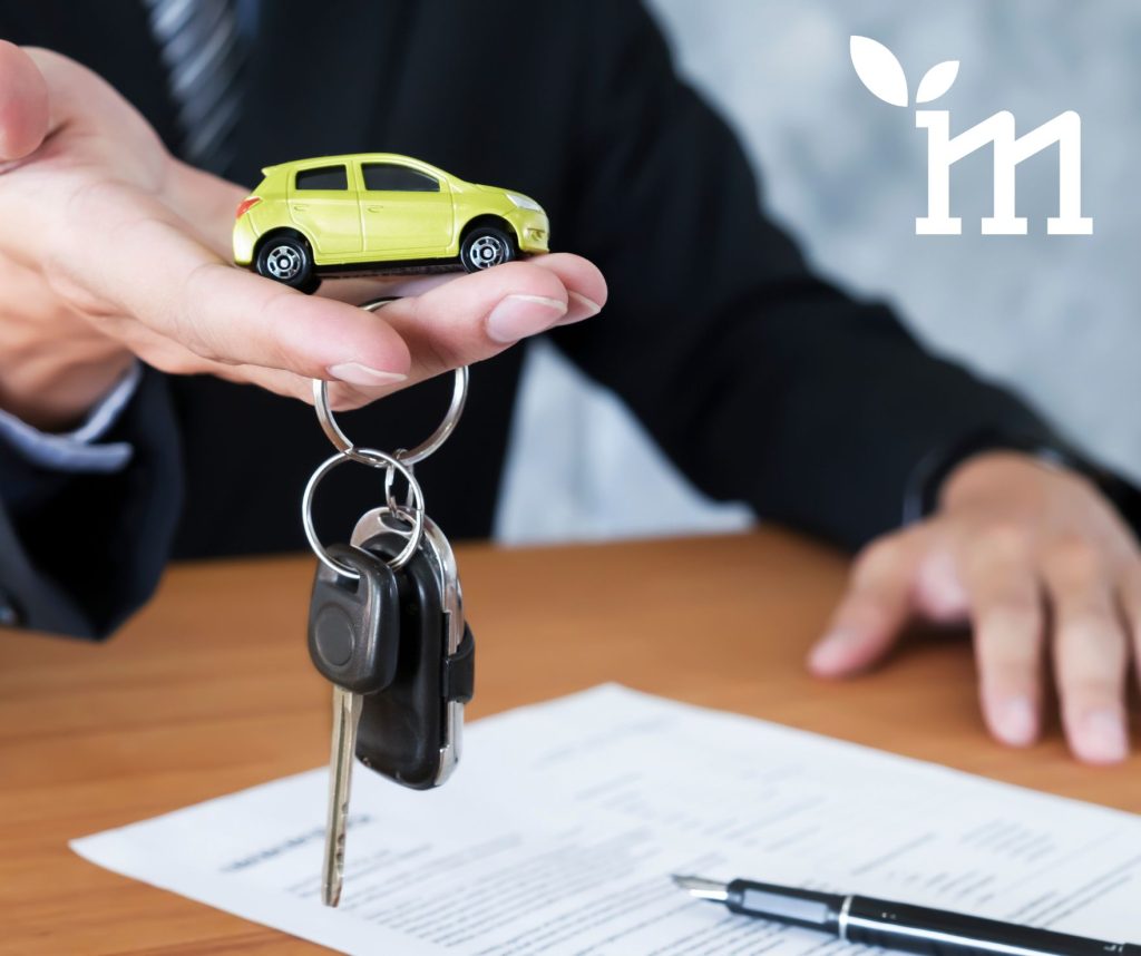 Ręka trzyma klucze od samochodu i mały samochodzik