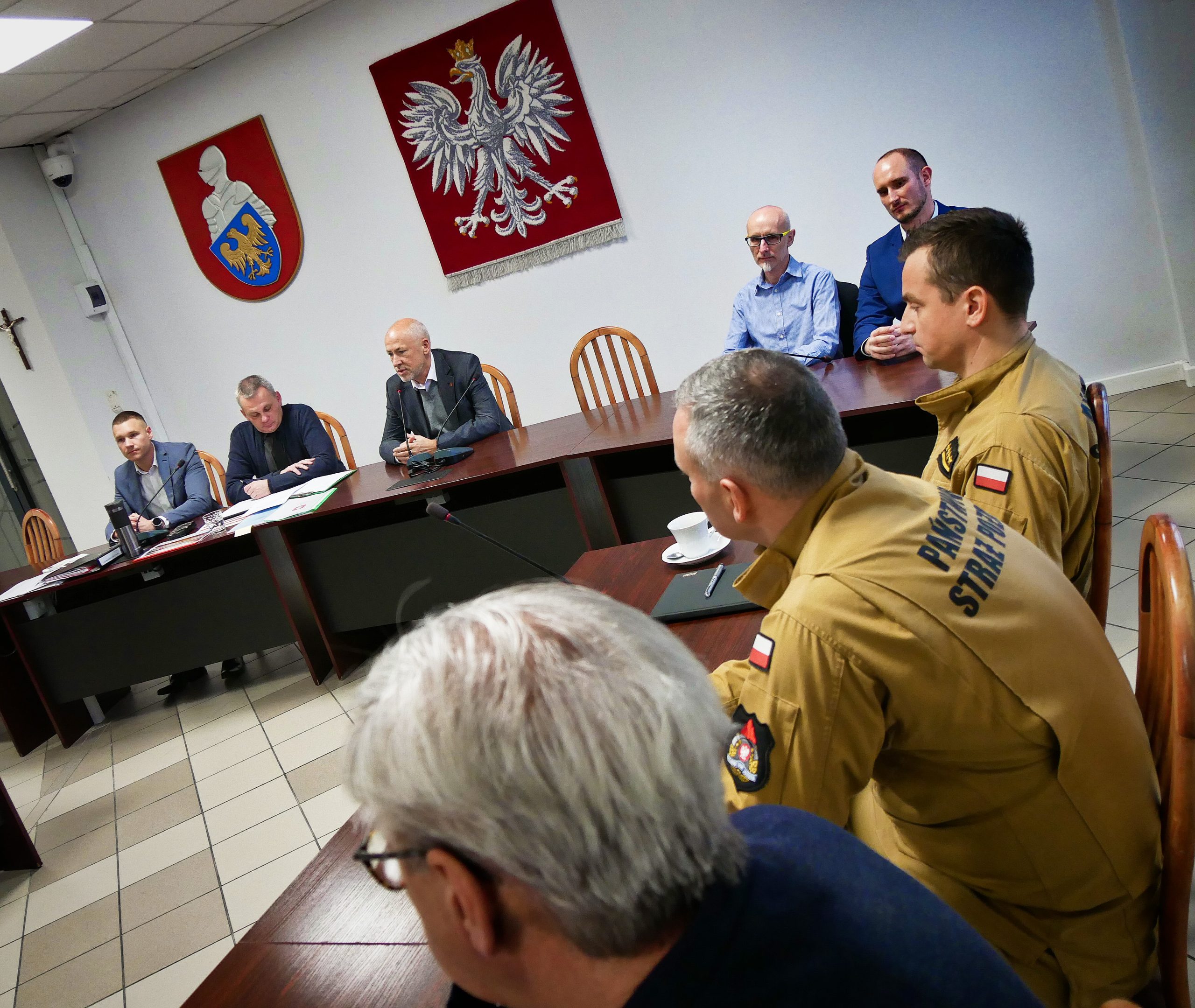 Straż pożarna oraz kierownictwo ćwiczeń siedzą przy stołach naprzeciwko siebie